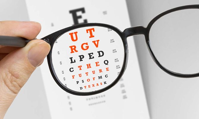 A pair of glasses in a frame, looking at an eye chart, in the eye chart is the phrase UT RGV